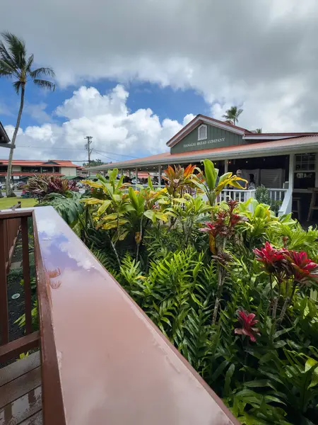 Hanalei, Kauai, Hawaii, ABD - 9 Nisan 2024: Kalabalık Hanalei Ekmek Şirketi bulutlu mavi gökyüzüne karşı