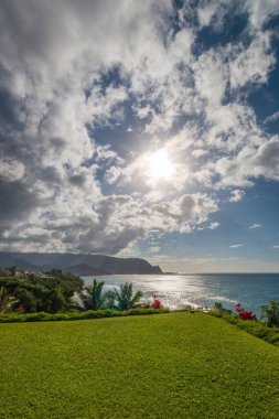 Hawaii 'nin Kauai adasının kuzey kıyısının manzarası öğleden sonra ünlü Napali kıyılarıyla bulutlu mavi gökyüzüne karşı.