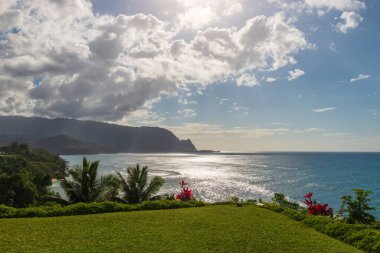 Hawaii 'nin Kauai adasının kuzey kıyısının manzarası öğleden sonra ünlü Napali kıyılarıyla bulutlu mavi gökyüzüne karşı.