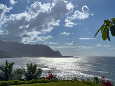 Hawaii 'nin Kauai adasının kuzey kıyısının manzarası öğleden sonra ünlü Napali kıyılarıyla bulutlu mavi gökyüzüne karşı.