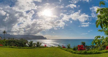 Hawaii 'nin kuzeyindeki Kauai adasının panoramik manzarası öğleden sonra ünlü Napali kıyılarıyla birlikte bulutlu mavi gökyüzüne karşı.