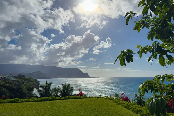 Hawaii 'nin Kauai adasının kuzey kıyısının manzarası öğleden sonra ünlü Napali kıyılarıyla bulutlu mavi gökyüzüne karşı.