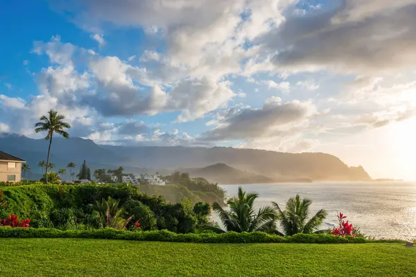 Hawaii 'nin Kauai adasının kuzey kıyısının manzarası. Gün batımında ünlü Napali kıyıları ile bulutlu mavi gökyüzüne karşı.