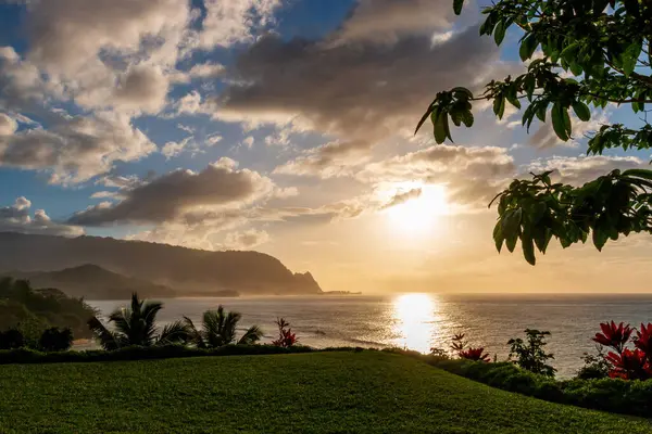 Hawaii 'nin Kauai adasının kuzey kıyısının manzarası. Gün batımında ünlü Napali kıyıları ile bulutlu mavi gökyüzüne karşı.