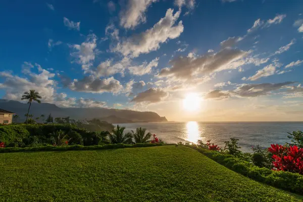 Hawaii 'nin Kauai adasının kuzey kıyısının manzarası. Gün batımında ünlü Napali kıyıları ile bulutlu mavi gökyüzüne karşı.