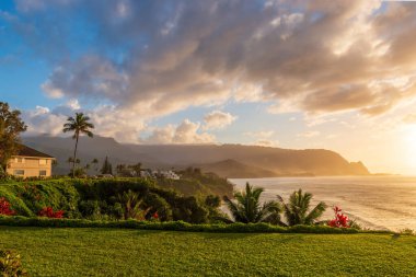 Hawaii 'nin Kauai adasının kuzey kıyısının manzarası. Gün batımında ünlü Napali kıyıları ile bulutlu mavi gökyüzüne karşı.