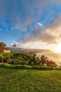 Hawaii 'nin Kauai adasının kuzey kıyısının manzarası. Gün batımında ünlü Napali kıyıları ile bulutlu mavi gökyüzüne karşı.