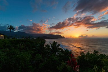 Hawaii 'nin Kauai adasının kuzey kıyısının manzarası. Gün batımında ünlü Napali kıyıları ile bulutlu mavi gökyüzüne karşı.
