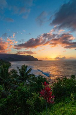 Hawaii 'nin Kauai adasının kuzey kıyısının manzarası. Gün batımında ünlü Napali kıyıları ile bulutlu mavi gökyüzüne karşı.