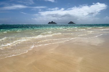 ABD 'nin Hawaii eyaletinin Oahu adasındaki ünlü Lanikai Sahili' ndeki İkiz Adalar veya Mokulua Adaları 'nın mavi gökyüzüne karşı manzarası.