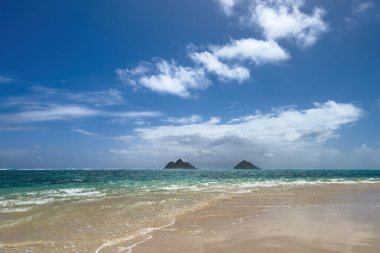 ABD 'nin Hawaii eyaletinin Oahu adasındaki ünlü Lanikai Sahili' ndeki İkiz Adalar veya Mokulua Adaları 'nın mavi gökyüzüne karşı manzarası.