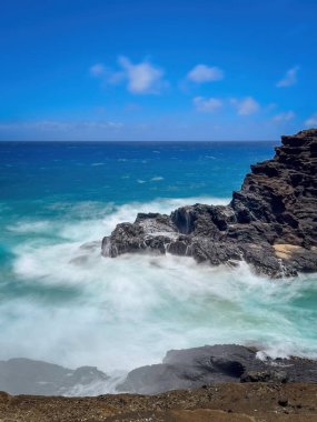 Halona Koyu, Oahu, Hawaii, ABD Pasifik Okyanusu 'na ve bulutlu mavi gökyüzüne karşı uzun pozlu manzara