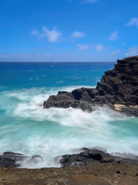 Halona Koyu, Oahu, Hawaii, ABD Pasifik Okyanusu 'na ve bulutlu mavi gökyüzüne karşı uzun pozlu manzara