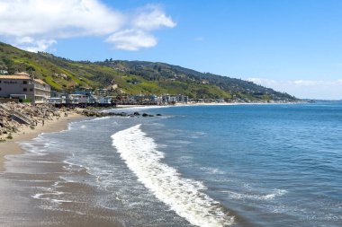 Karbon Sahili 'nin manzarası ve deniz kenarındaki sazlıklar, Malibu, California, ABD' de Nisan 2024 'te bulutlu mavi gökyüzüne karşı