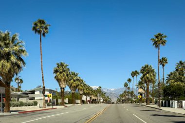Palm Springs, California, USA - April 16, 2024: Scenic view of North Palm Canyon Drive looking north against San Gorgonio Mountain and blue sky
