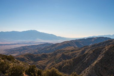 Keys View 'den manzara Küçük San Bernadino Dağları' ndaki Joshua Tree Ulusal Parkı 'ndan San Jacinto Dağı, San Andreas Fay Dağı ve Coachella Vadisi, Kaliforniya, ABD' de mavi gökyüzüne karşı