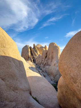 Arch Rock Trail 'deki kaya oluşumunun manzarası, Joshua Tree Ulusal Parkı, Kaliforniya, Birleşik Devletler mavi gökyüzüne karşı bulutlar