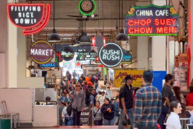 Los Angeles, Kaliforniya, ABD - 18 Nisan 2024: Kalabalık bir atmosferde çeşitli yiyecek tezgahlarını ve neon ışıklarını keşfeden ziyaretçilerle dolu Büyük Merkez Pazarı