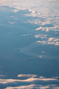 ABD 'nin Güney Dakota şehrinden geçen kıvrımlı Missouri Nehri' nin hava görüntüsü, yüksek irtifada dağınık bulutların arasından bir uçuş sırasında görülüyor.