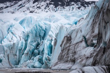 İzlanda 'daki Vatnajkull Ulusal Parkı' ndaki Svnafellskull buzulunda derin yarıkların ve çarpıcı mavi buz oluşumlarının yakın görüntüsü.