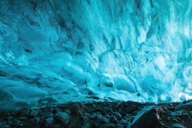 İzlanda 'daki Breidamerkurjokull buzulunda görkemli bir doğal mağaranın içindeki canlı mavi buz duvarı.