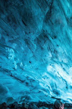 İzlanda 'daki Breidamerkurjokull buzulunda görkemli bir doğal mağaranın içindeki canlı mavi buz duvarı.