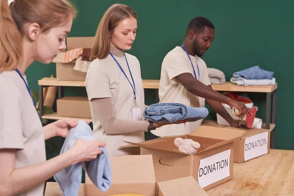Group Modern Multi Ethnic Volunteers Sorting Packing Clothes Cardboard Boxes — Stock Photo, Image