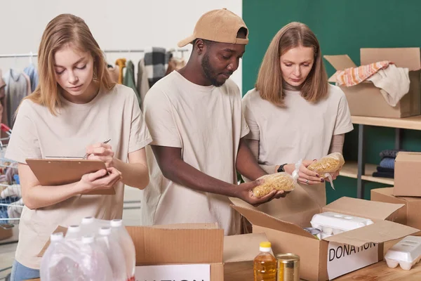 Grupo Três Voluntários Multiétnicos Que Trabalham Conjunto Para Separar Embalar — Fotografia de Stock