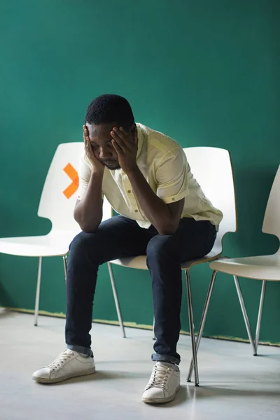 Pystysuora Täysi Laukaus Afrikkalainen Amerikkalainen Nuori Mies Istuu Yksin Tuolilla — kuvapankkivalokuva