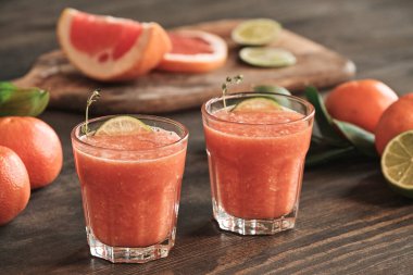 Yemek masasında limon dilimleri ve narenciye ile sulu, ferahlatıcı greyfurt içeceklerinin yakın çekimi.