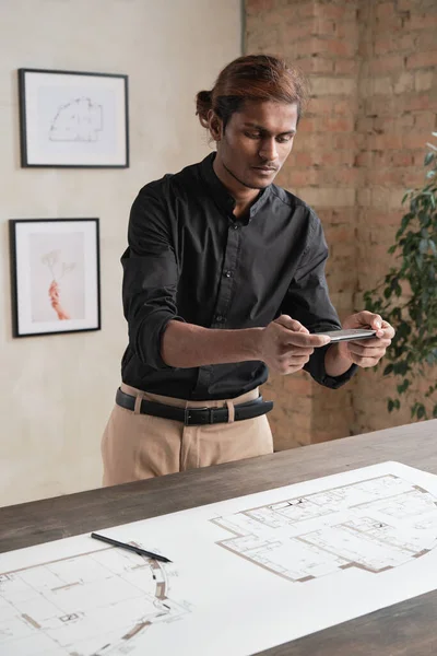 Komoly Fiatal Indiai Építész Fekete Ingben Áll Asztalnál Fényképezés Tervrajz — Stock Fotó