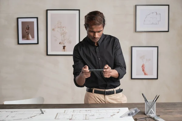 Σοβαρός Νεαρός Ινδός Αρχιτέκτονας Στέκεται Στο Γραφείο Φωτογραφίες Στον Τοίχο — Φωτογραφία Αρχείου
