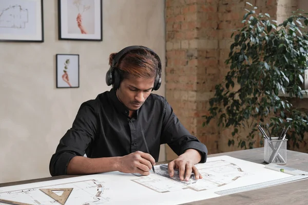 Συγκεντρωμένος Νεαρός Ινδός Αρχιτέκτονας Ασύρματα Ακουστικά Κάθεται Στο Τραπέζι Και — Φωτογραφία Αρχείου