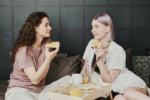 Positivo Joven Caucásico Lesbianas Pareja Sentado Cama Con Bandeja Comer — Foto de Stock