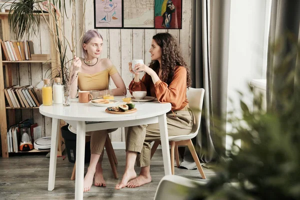 Çekici Genç Lezbiyenler Yemek Masasında Oturup Kahvelerini Içerken Evde Sohbet — Stok fotoğraf