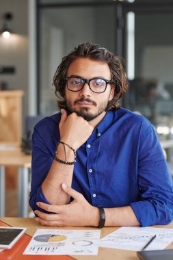 İçerik portresi. Gözlüklü yakışıklı Yahudi strateji yöneticisi. Masasında grafikler ve grafiklerle oturuyor.