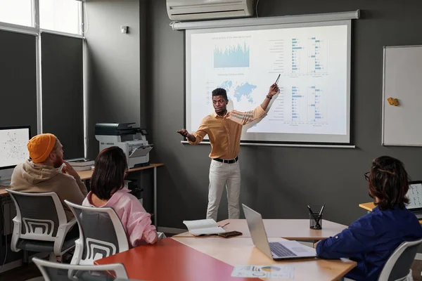 Junger Schwarzer Manager Zeigt Auf Projektionsfläche Und Präsentiert Graphiken Während — Stockfoto