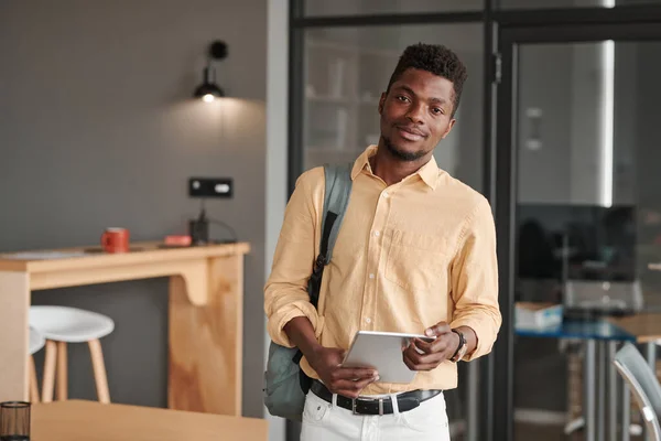 stock image Portrait of content modern African-American student standing with digital tablet and satchel in cafe