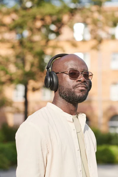 Retrato Hombre Negro Serio Con Gafas Sol Auriculares Inalámbricos Caminando —  Fotos de Stock