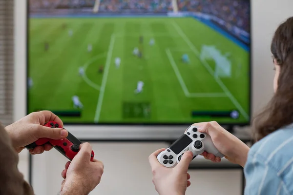 stock image Rear view of boy playing video game together with his mom while they sitting in front of TV screen