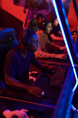 Esports Club 'da online bilgisayar oyunu oynayan konsantre genç bilgisayar oyuncuları grubu