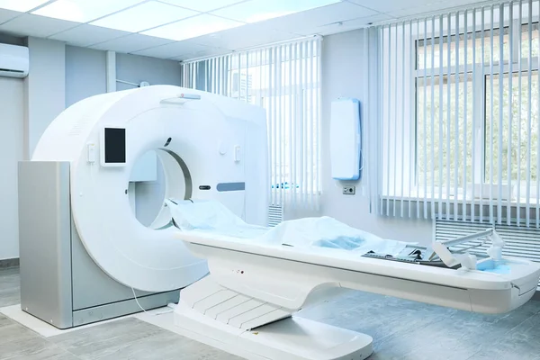 Hastane odasındaki tek kullanımlık çarşaflarla kaplı modern büyük bilgisayar tomografi makinesi.