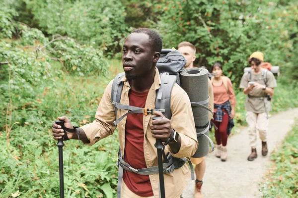 熟练的年轻黑人向导 站在一群林子里远足的人面前 — 图库照片