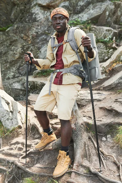 年轻的非洲裔美国徒步旅行者的画像 背负着行走杆 靠着岩石山 背包里有运动垫 — 图库照片