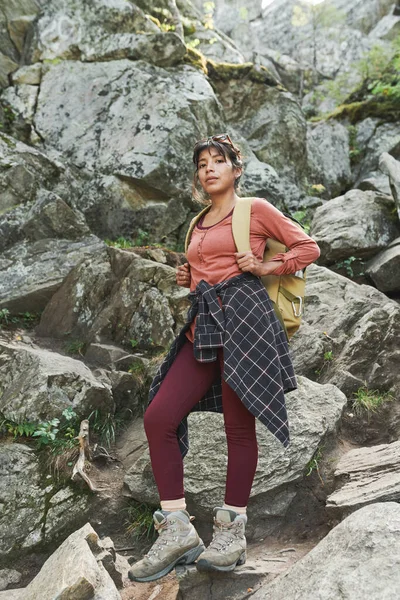严肃的年轻女性攀登者的画像 腰围着背包和衬衫 站在石头上 — 图库照片