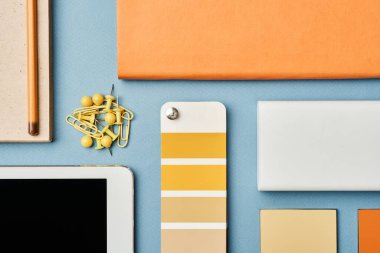 Tasarımcıların masasındaki renk kumaşı, düzenleyici, tablet, iğne ve kalem görünümünün tam üstünde