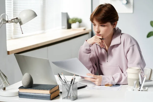 Poważny Biały Dziewczyna Bluzie Siedzi Przy Biurku Patrząc Ekranie Laptopa — Zdjęcie stockowe