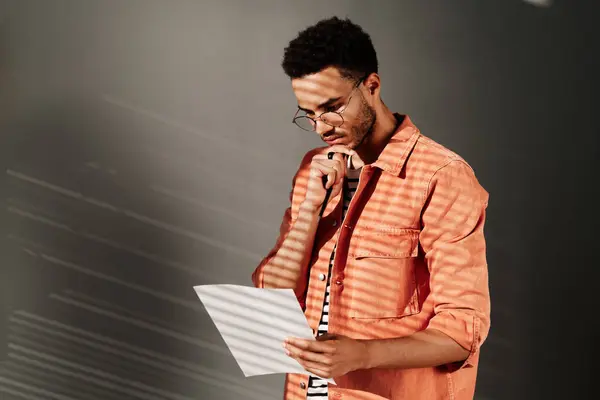 Vakava Kiireinen Nuori Musta Mies Parta Koskettaa Leuka Analysoidessaan Papereita — kuvapankkivalokuva