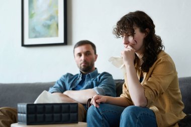 Depresyonda olan genç bir kadın kocasıyla birlikte psikoloğa giderken mendil kullanıyor.