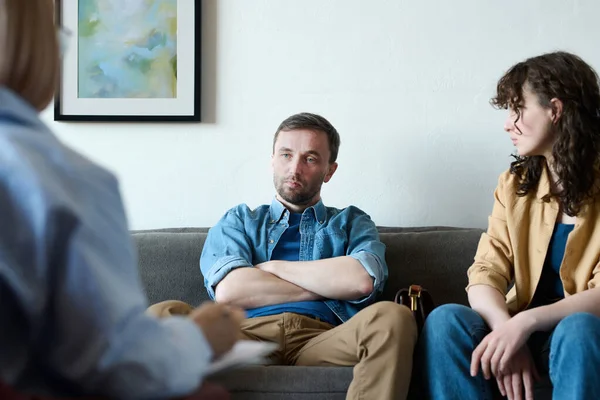 stock image Young couple having argument sitting on sofa and talking to psychologist about their problems